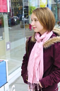 Teenage girl window shopping on city street