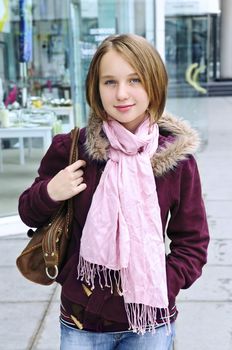 Teenage girl window shopping on city street