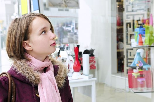 Teenage girl window shopping on city street