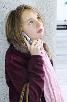 Teenage girl talking on cell phone outside