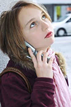 Teenage girl talking on cell phone outside