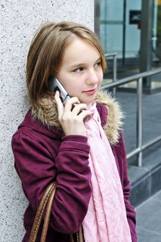Teenage girl talking on cell phone outside