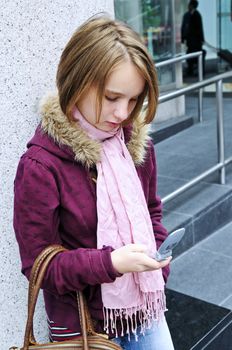 Teenage girl text messaging on cell phone