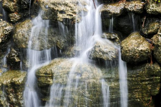 Waterfall over natural stones in japanese zen garden