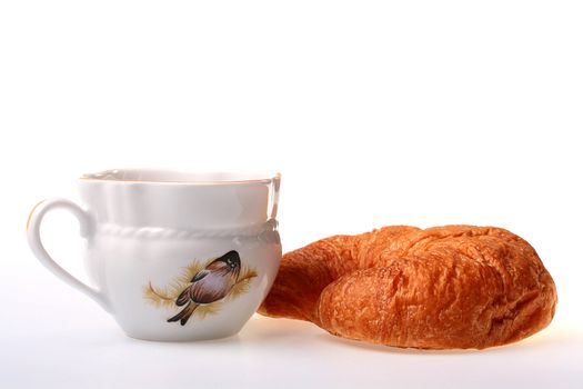 Cornetto on a saucer with a cup of black tea.