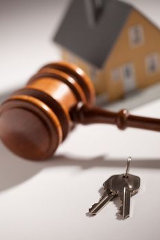 Gavel, House Keys and Model Home on Gradated Background with Selective Focus.