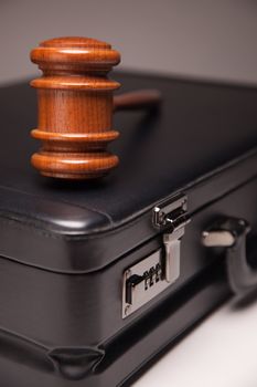 Gavel and Black Briefcase on Gradated Background with Selective Focus - Business Law Concept.