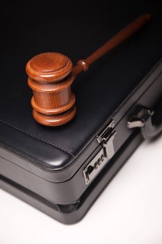 Gavel and Black Briefcase on Gradated Background with Selective Focus - Business Law Concept.