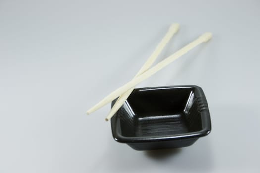 saucer and japanese sticks on gray background