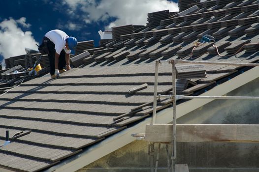 Roofer Laying Tile Shingles on a New Home