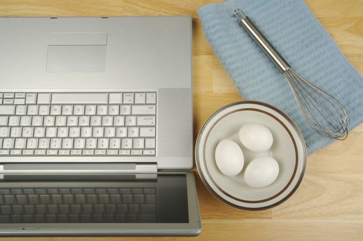 Laptop, eggs and mixer - online research for cooking and recipe information.