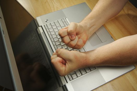 Frustrated businessman shows his frustration while working on his laptop.