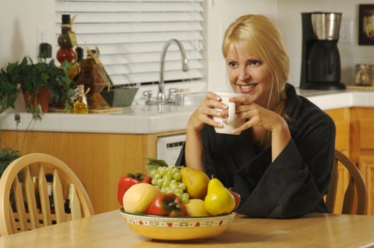 Beautiful young successful woman, enjoying a cup of coffee in her home.