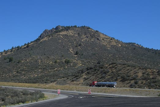 Trucker rushes past picturesque truck stop in Northern California.