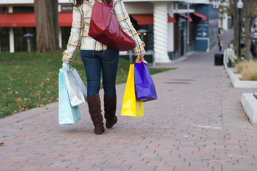 An attractive young woman out in the city carrying shopping bags..