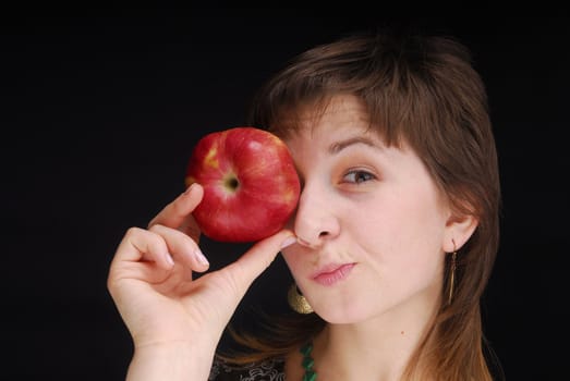 Woman with apple near her eyes