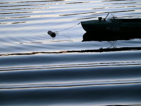 Boat on the rivers waves in the evening