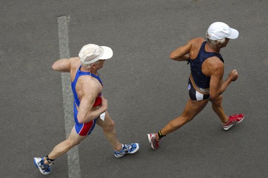 Two competitiors in a triathlon race, taken from above. Motion blur on their feet.