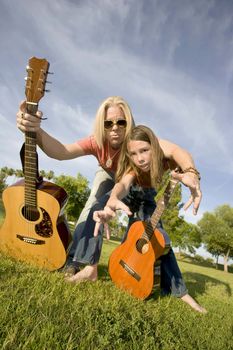 Father and son with guitars grab at the camera