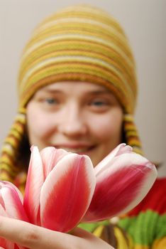 Buds of tulips and girl in yellow cap on background 