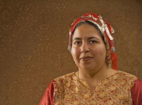 Muslim Woman in a Red Scarf in front of a Gold Wall