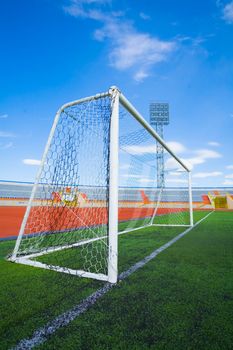 Football field with goal and tablo on blue sky