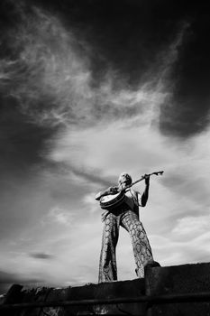 Banjo Player with groovy clothes against a wide sky