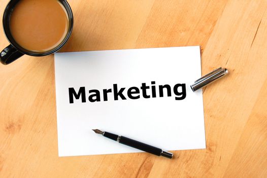 marketing concept with pen paper and cup of coffee