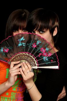 Girls with a spanish fan, on black background