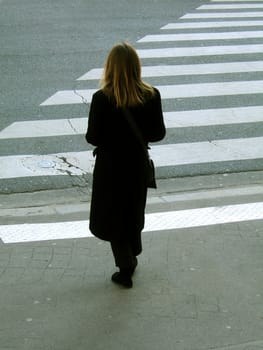 Young adult woman waiting before crossing the road
