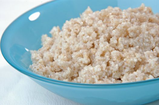 groats porridge in  plate on white