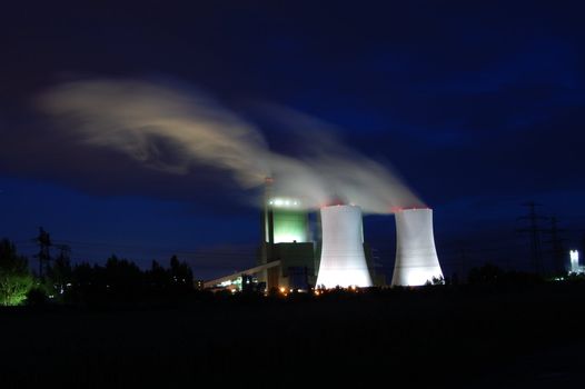 a smoking industrial power plant at night