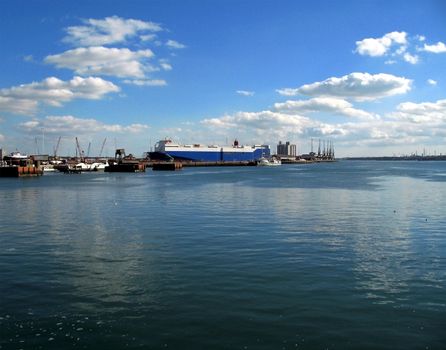 Portside view of docks with small boats and cargo vessel