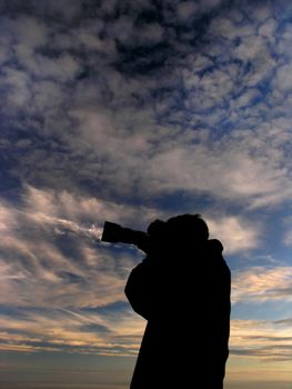 Photographer with beautiful clouds in background