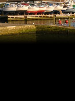 A group of boats at the marina with dark copyspace below