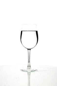 Glass of water with reflection on white background.