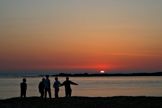 Group of friends playing at sunset.