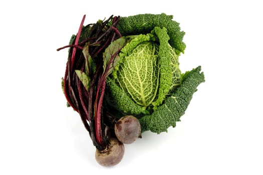 Single green cabbage with raw red beetroot on a reflective white background