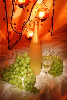 Candle, bottle of wine and grapes