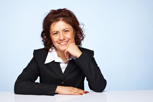 Image of a happy business woman smiling against blue background