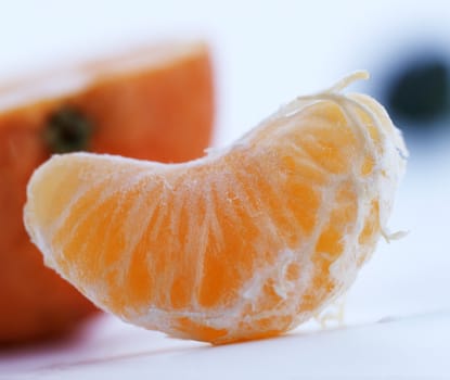 Slice of a ripe tangerine on white background