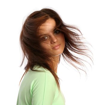 Young brunette girl with a hairdress in movement, isolated on white