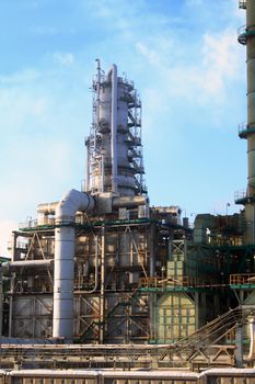 Closeup of oil refinery construction on background with blue sky