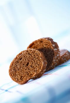 Closeup photo of slices of rye bun with sesame.