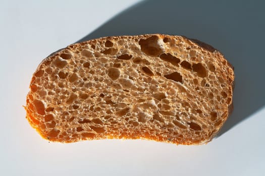 Closeup texture of section of ciabatta on white background.