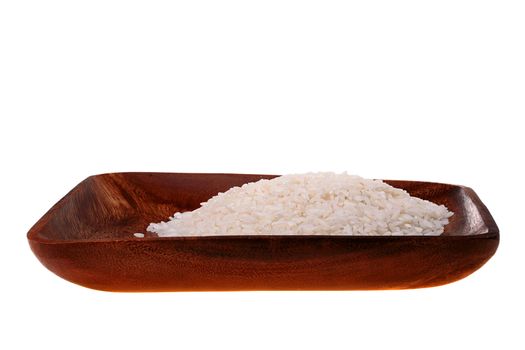 Rice grains in a wooden plate on a white background.