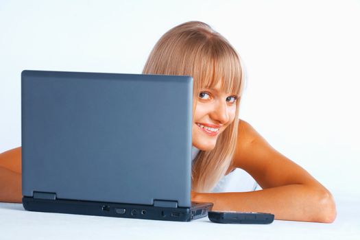 Young women peeping out from the laptop, laing on the floor