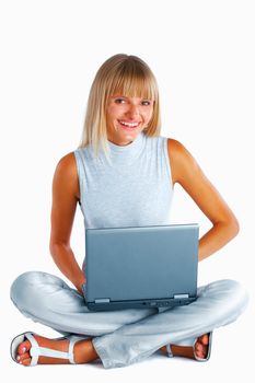 Smiling woman sitting with her legs crossed on the floor with laptop