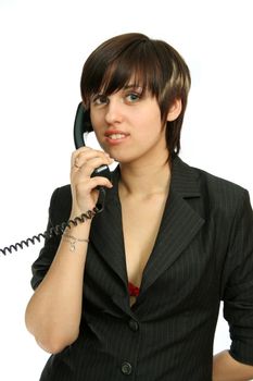 The young nice girl speaks by phone with a smile, isolated on white