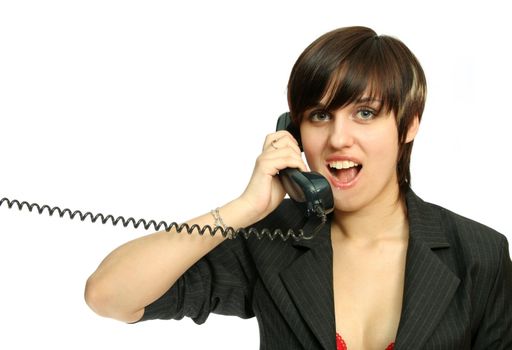 The young nice girl speaks by phone with a smile, isolated on white